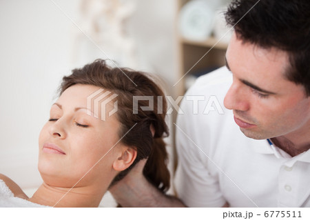 A doctor massaging the head of his patient while holding it 6775511