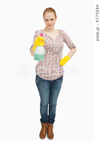 Woman standing while holding a spray bottle Woman standing while holding a spray bottle 6775684