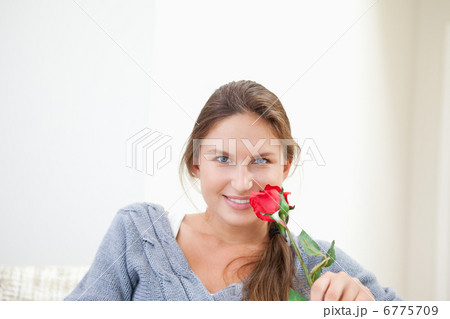 Woman holding a rose while smiling 6775709