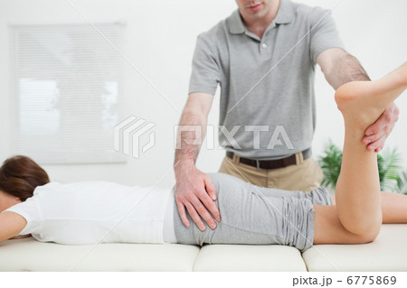 Woman lying while being stretched by a doctor 6775869