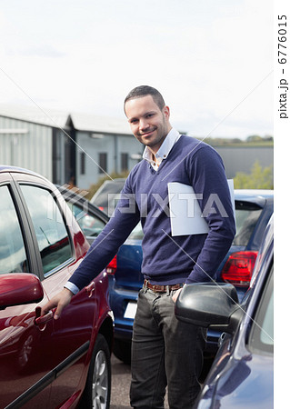 Man holding a car handle while holding a file 6776015