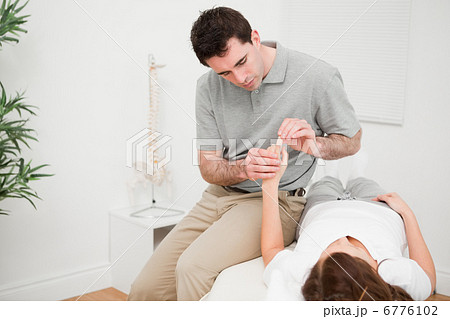 Physiotherapist moving the forefinger of a patient 6776102