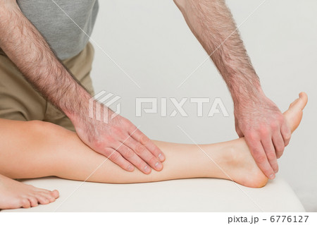 Physiotherapist touching the calf and the foot of a patient 6776127