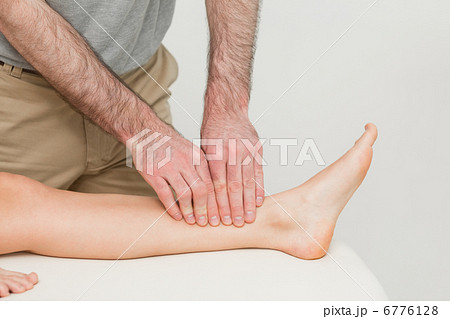 Doctor using his fingertips to massage a calf 6776128