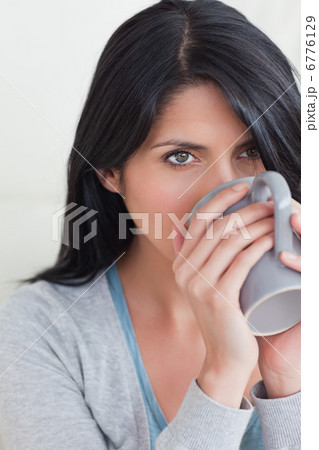 Close-up of a woman drinking from a mug 6776129
