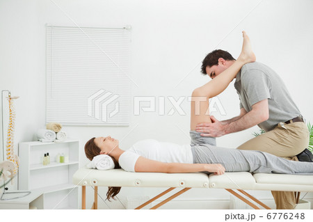 Doctor examining the thigh of a woman while putting her foot on 6776248