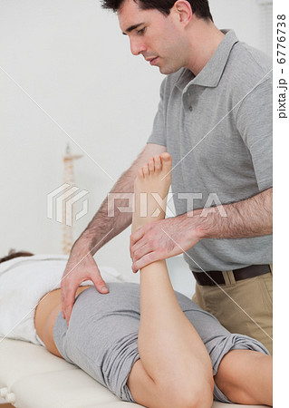 Woman lying while a physiotherapist is bending her leg Woman lying while a physiotherapist is bending her leg 6776738