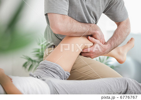 Man manipulating the leg of a woman while she is lying 6776767