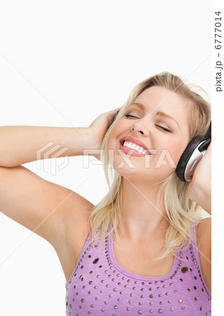 Blonde woman leaning her head while listening to music Blonde woman leaning her head while listening to music 6777014