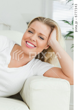 Woman lying on a sofa with a hand in her hair Woman lying on a sofa with a hand in her hair 6777343