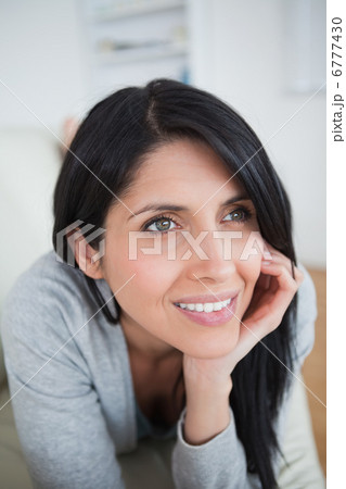 Woman smiling as she holds her head with her palm Woman smiling as she holds her head with her palm 6777430