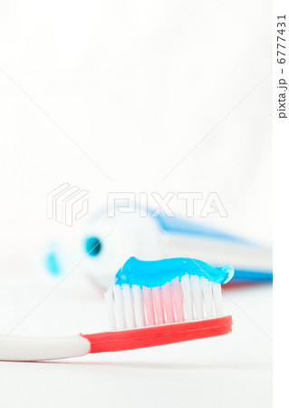 Red toothbrush next to a tube of toothpaste 6777431