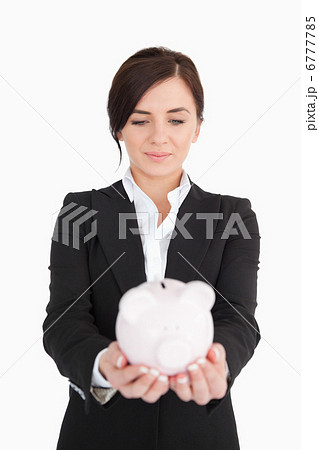 Businesswoman looking at a piggy-bank Businesswoman looking at a piggy-bank 6777785