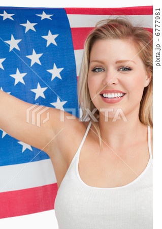 Smiling woman holding the Old Glory flag 6777981