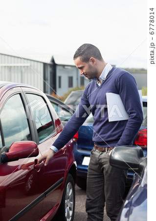 Man looking at a car door while opening it 6778014