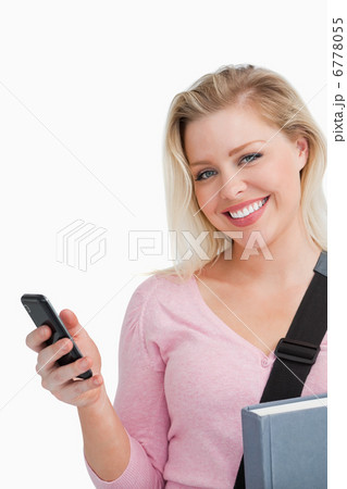Smiling woman holding her cellphone and a novel Smiling woman holding her cellphone and a novel 6778055