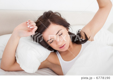 Peaceful woman stretching her body while lying 6778190