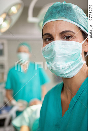 Smiling surgeon standing in front of a colleague 6778274