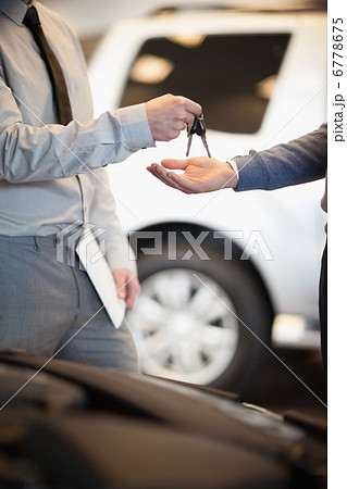 Salesman handing keys to a customer 6778675