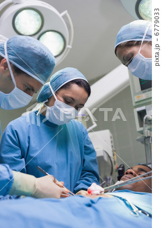 Doctors operating with surgical tools Doctors operating with surgical tools 6779033