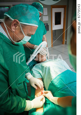 Surgeon using a scalpel to open a patient 6779543