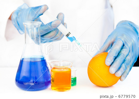 Chemist injecting product in an orange 6779570