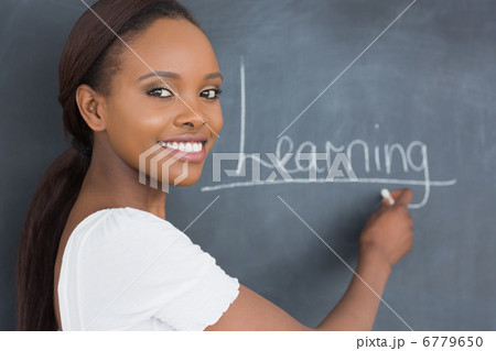 Teacher showing the blackboard while smiling 6779650