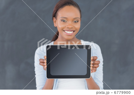 Black woman holding a tablet computer next to a blackboard 6779900