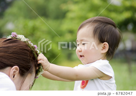 花冠をお母さんにあげる幼児 はいどうぞの写真素材