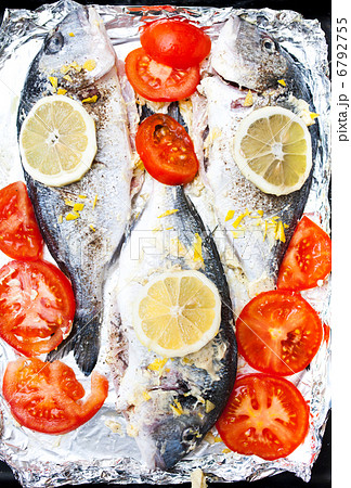 Fresh Sea Bream with lemon, tomatoes and spices on cooking foil 6792755