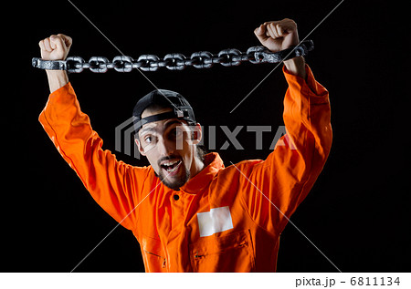 Inmate chained on black background 6811134