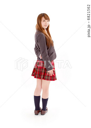 可愛らしいポーズで後ろを振り向くセーラー服を着たキュートな女子校生の写真素材