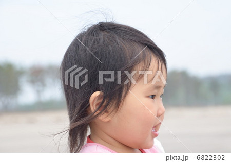 浜辺で見つめる女の子の写真素材