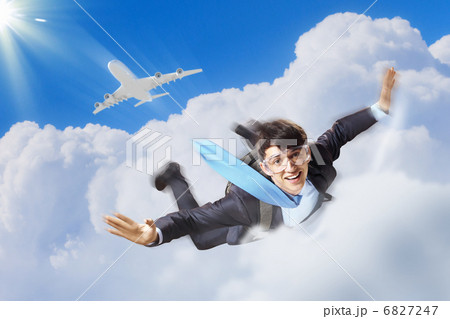 Young businessman flying with parachute on back 6827247