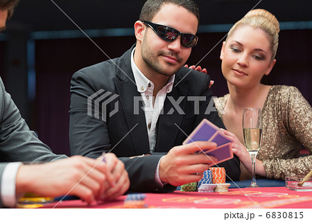 Man in sunglasses showing hand to woman beside him 6830815