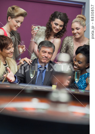 Man surrounded by women accepting of loss 6830857