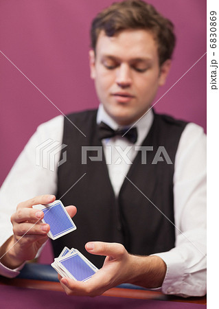 Dealer shuffling cards in a casino 6830869