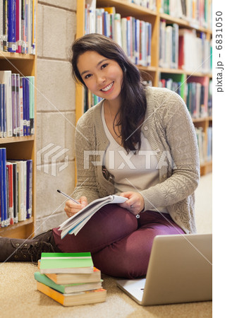 Smiling student working on library floor Smiling student working on library floor 6831050