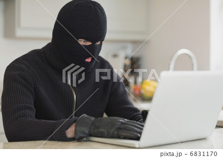 Burglar hacking a laptop Burglar hacking a laptop 6831170