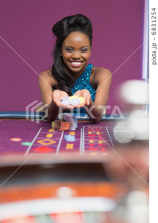Woman smiling holding up chips Woman smiling holding up chips 6831254