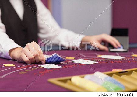 Dealer distributing cards at table 6831332