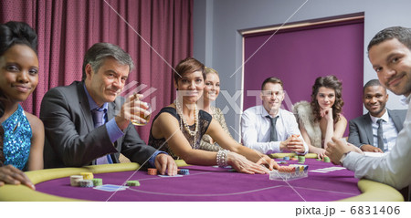 Smiling group at poker table 6831406