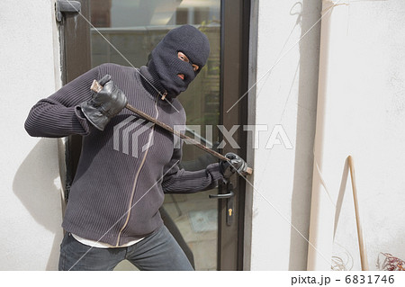 Robber breaking into house using crow bar Robber breaking into house using crow bar 6831746