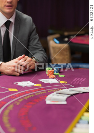 Man sitting at poker table with cards and chips 6832321