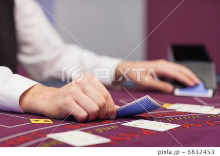 Dealer distributing cards in a casino 6832453