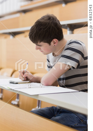 Concentrated student sitting while writing 6832543