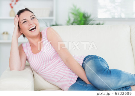 Laughing woman relaxing on the couch 6832689