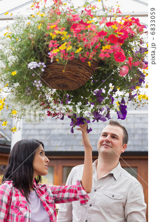 Couple touching the hanging flower basket 6833059