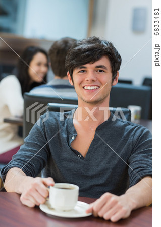 Man sitting at table drinking coffee 6833481