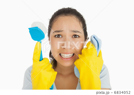 Distressed woman holding cloth and scrubbing brush 6834052